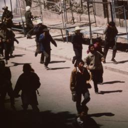 Tibetans covering their fac...