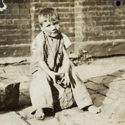 Boy Sitting on Paving Stone