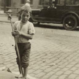 Boy with Stick on Curb